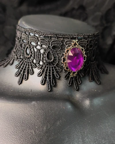 Gargantilha de renda com camafeu roxo central e detalhes ornamentais prateados.