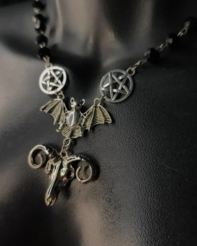 Colar de morcego com pentagramas prateados, contas pretas e pingente de crânio de bode.